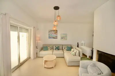a living room with a couch and a table at Villa Cove - Villa in complex only 5 minutes from the Marina of Vilamoura in Quarteira