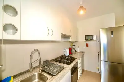 a kitchen with white cabinets and a stainless steel refrigerator at Villa Cove - Villa in complex only 5 minutes from the Marina of Vilamoura in Quarteira