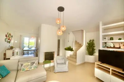 a living room with a couch and a tv at Villa Cove - Villa in complex only 5 minutes from the Marina of Vilamoura in Quarteira