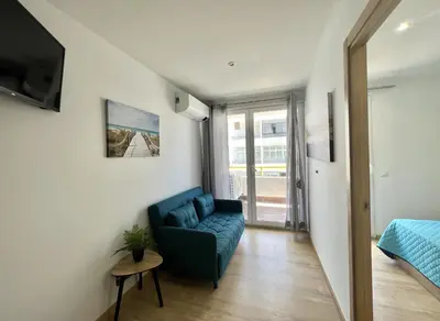 a living room with a blue couch and a bed at Miral 4 - 100 mtr to beach by HD PROPERTIES in Quarteira