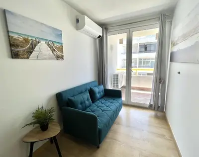 a living room with a blue couch in front of a window at Miral 4 - 100 mtr to beach by HD PROPERTIES in Quarteira
