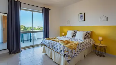 a bedroom with a bed and a large window at Sun House by LovelyStay in Albufeira