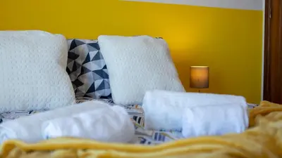 a bed with two white chairs and a lamp at Sun House by LovelyStay in Albufeira