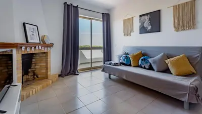 a living room with a couch and a fireplace at Sun House by LovelyStay in Albufeira