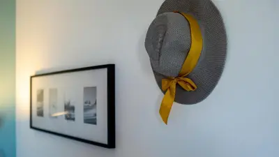 a hat hanging on a wall next to a picture at Sun House by LovelyStay in Albufeira