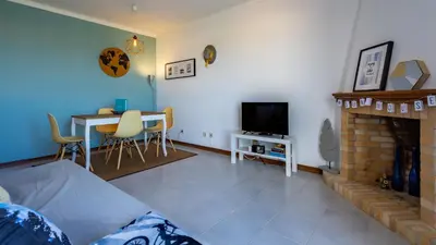 a living room with a fireplace and a dining table at Sun House by LovelyStay in Albufeira