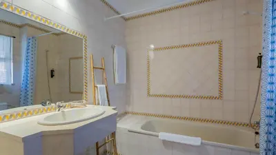a bathroom with a tub and a sink and a bath tub at Sun House by LovelyStay in Albufeira