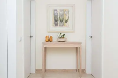 a console table in a hallway with a picture on the wall at Vilamoura Apartment Jacaranda - By Dalma Portuguesa in Vilamoura