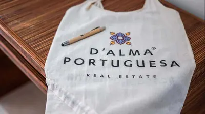 a bag sitting on a table with a pen on it at Vilamoura Apartment Jacaranda - By Dalma Portuguesa in Vilamoura