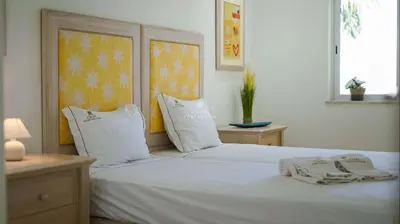 a white bed with two towels on top of it at Vilamoura Apartment Jacaranda - By Dalma Portuguesa in Vilamoura