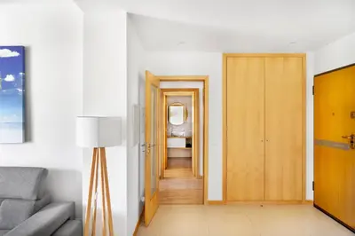 a kitchen with wooden cabinets and a sink and a window at Apartamento no Condomínio Baia Village com Piscina in Albufeira
