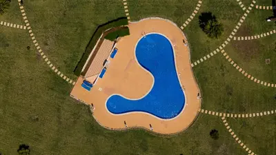 an aerial view of a building with a blue pond at Apartamento no Condomínio Baia Village com Piscina in Albufeira