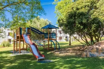 a playground with a slide in a park at Lovely 2 Bedroom Home inside a Resort in Albufeira in Albufeira