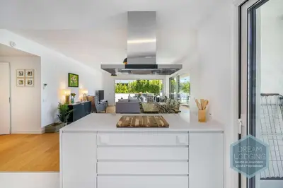 a kitchen with a white counter top and a living room at Albufeira Prime 1B - Dream Lodging in Albufeira