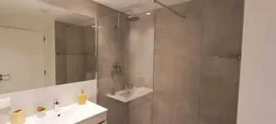 a bathroom with a shower with a sink and a mirror at 209 Modern Apartment in central Albufeira close to everything in Albufeira