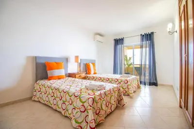 a bedroom with two beds and a window at Apartamento Varandas do Sol in Vilamoura