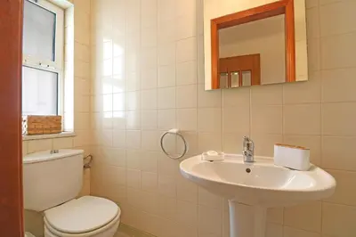 a white bathroom with a toilet and a sink at Apartamento Varandas do Sol in Vilamoura