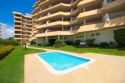 a swimming pool in front of a building at Apartamento Varandas do Sol in Vilamoura