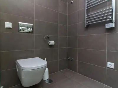 a bathroom with a toilet and a tiled wall at Harmony 4I House by Stay ici Algarve Holiday Rental in Albufeira