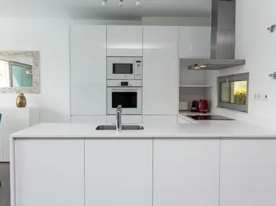 a white kitchen with white cabinets and a sink at Harmony 4I House by Stay ici Algarve Holiday Rental in Albufeira