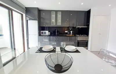 a kitchen with a stove and a table with chairs at T2 Tenis Golf Mar in Vilamoura
