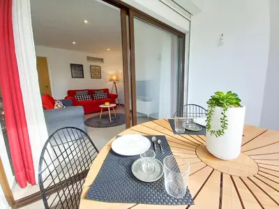 a living room with a table and a red couch at T2 Tenis Golf Mar in Vilamoura