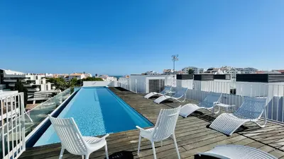 a deck with chairs and a swimming pool on a roof at Prime by Check-in Portugal in Albufeira