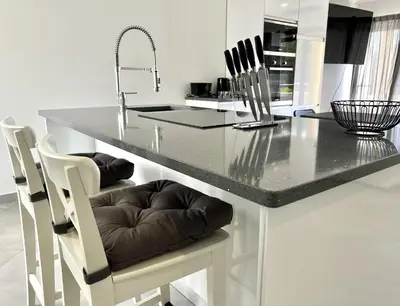 a kitchen with a counter with chairs and a table at Topazio - Pool & near the center by HD PROPERTIES in Vilamoura