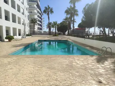 a swimming pool in front of a building at Beachside Apartment - With Pool by HD PROPERTIES in Quarteira