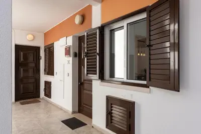 a hallway with wooden doors and a window at NUZZA - Vilamoura Marina with BBQ in Vilamoura