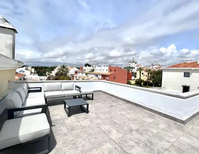 a rooftop patio with couches and tables on a building at Nancy Apartment - Near Vilamoura Marina by HD PROP in Vilamoura