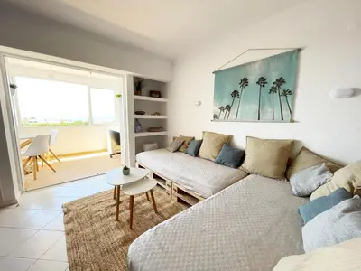 a living room with a couch and a table at Panoramic Seaview - 2 Bedroom, Main Ave, 15 Min Walk Beach, Workspace in Albufeira