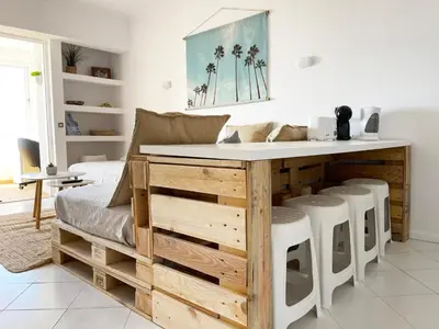 a kitchen with a table and stools in a room at Panoramic Seaview - 2 Bedroom, Main Ave, 15 Min Walk Beach, Workspace in Albufeira