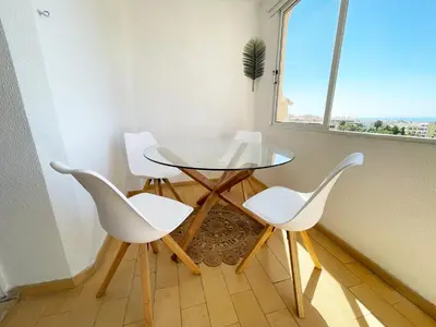 a table and four chairs in a room with a window at Panoramic Seaview - 2 Bedroom, Main Ave, 15 Min Walk Beach, Workspace in Albufeira