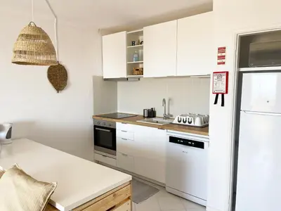 a kitchen with white cabinets and a white refrigerator at Panoramic Seaview - 2 Bedroom, Main Ave, 15 Min Walk Beach, Workspace in Albufeira