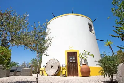 a small house with a yellow and white turret at Quinta Molinum Ad Mare in Boliqueime