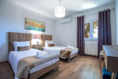 a bedroom with two beds and a desk and a window at Quinta Molinum Ad Mare in Boliqueime
