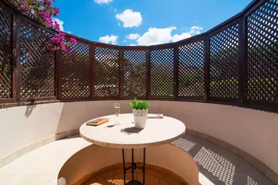 a small table on a balcony with a fence at Oceans 8. in Almancil