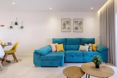 a living room with a blue couch and a table at Apartamento Centro de Albufeira Sunny in Albufeira