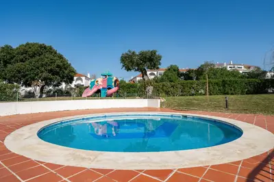 a swimming pool with a slide and a playground at Apartamento Centro de Albufeira Sunny in Albufeira
