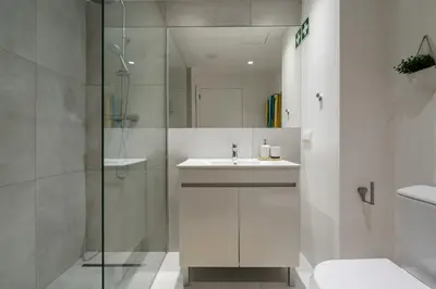 a bathroom with a sink and a glass shower at Apartamento Centro de Albufeira Sunny in Albufeira