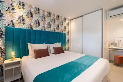 a bedroom with a large bed with a blue headboard at Apartamento Centro de Albufeira Sunny in Albufeira