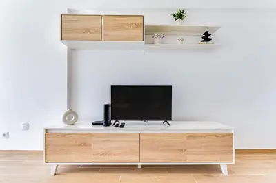 a white entertainment center with a television on top of it at T1 Albufeira city centre in Albufeira