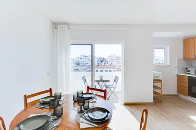 a kitchen and dining room with a table and chairs at T1 Albufeira city centre in Albufeira
