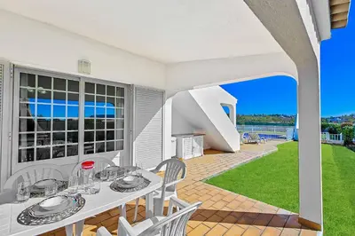 a white table and chairs on a patio with a view at Casa Palmeira in Terras Novas