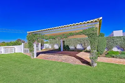 a pergola covered in ivy in a yard at Casa Palmeira in Terras Novas