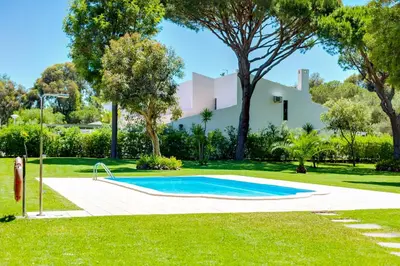 a swimming pool in a yard with a house in the background at AL - Barracuda Village in Vilamoura