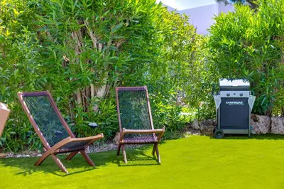 two chairs sitting on the grass next to a trash can at AL - Barracuda Village in Vilamoura