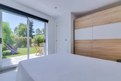 a bedroom with a white bed and a large window at AL - Barracuda Village in Vilamoura