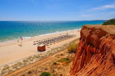 a beach with umbrellas and people on the beach at Vilamoura Marina, Av Tivoli in Vilamoura